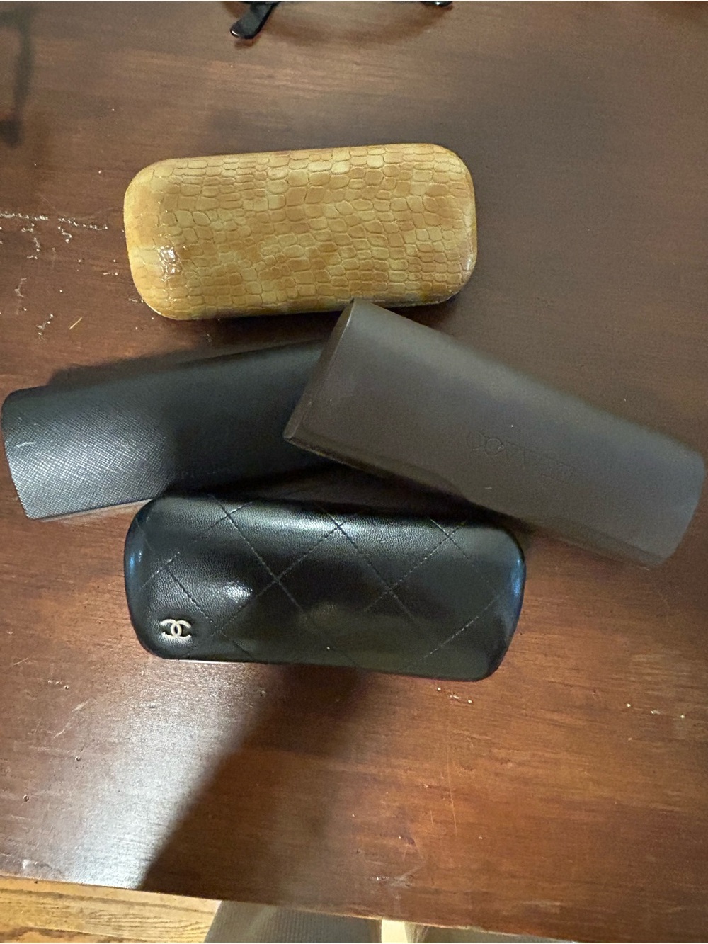 Four eye glasses cases. CHANEL, Prada, Oliver Peoples & generic